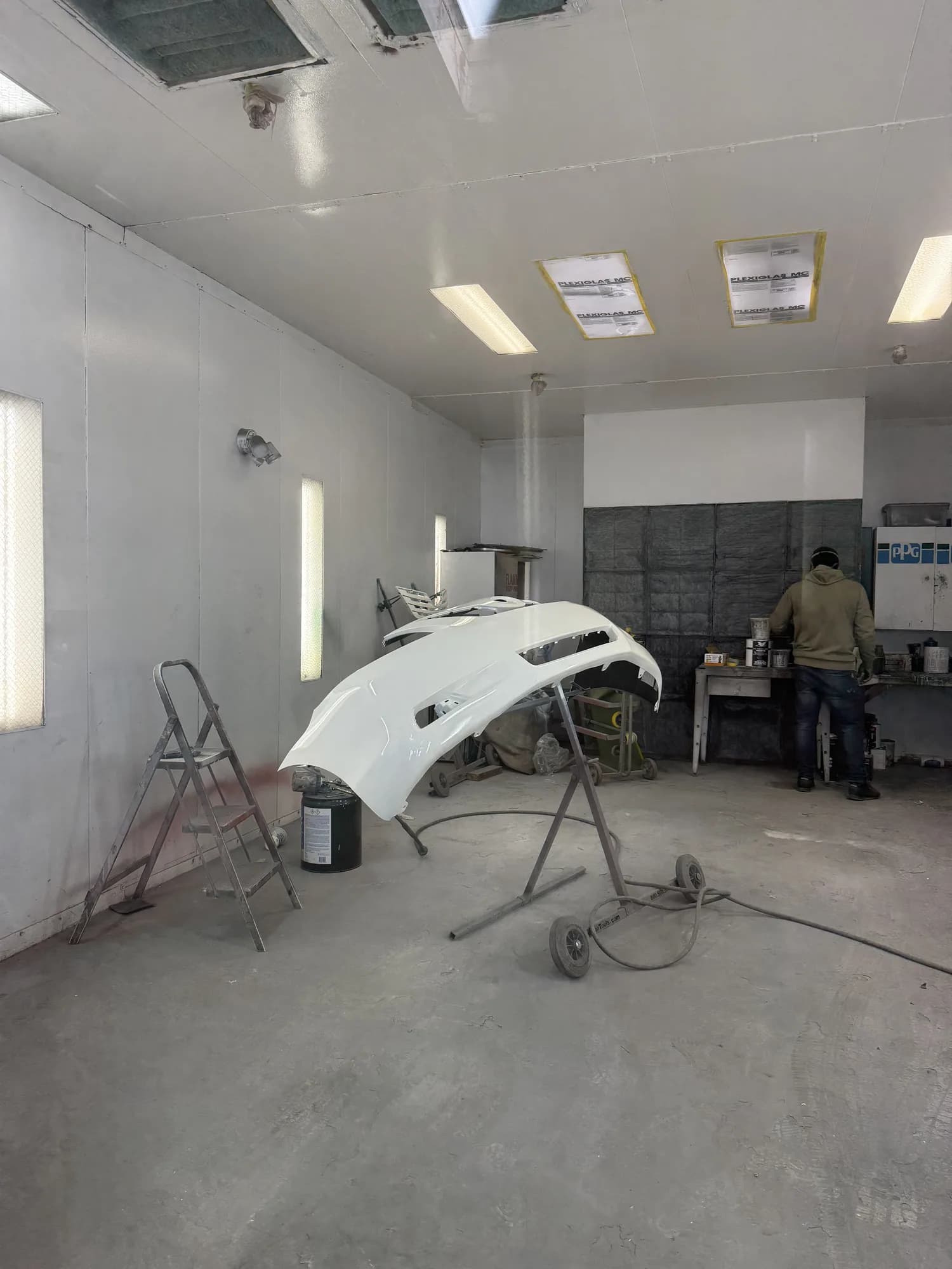 Bumper cover on a stand being refinished in the paint booth