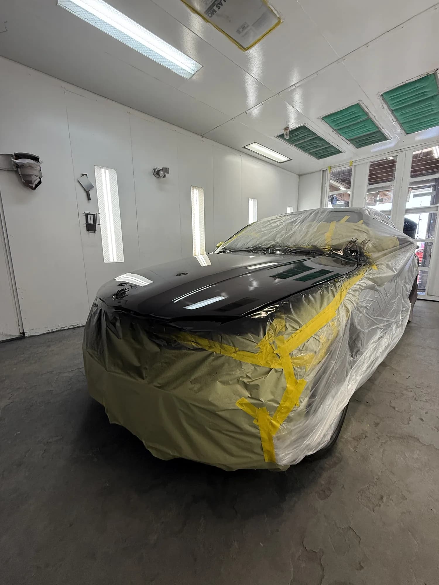 Side profile of a masked vehicle in the paint booth