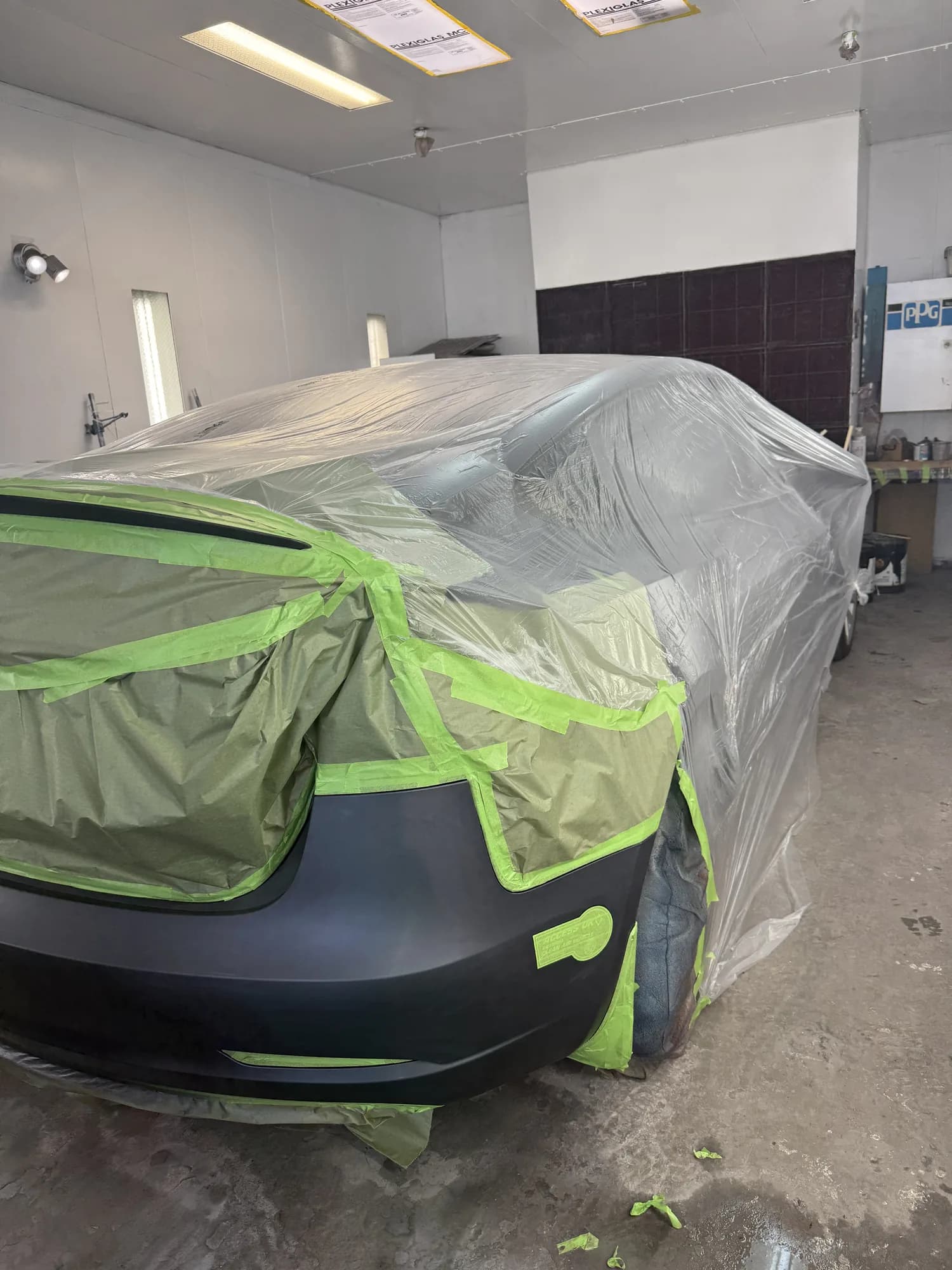 Masked vehicle prepped for paint under shop lighting
