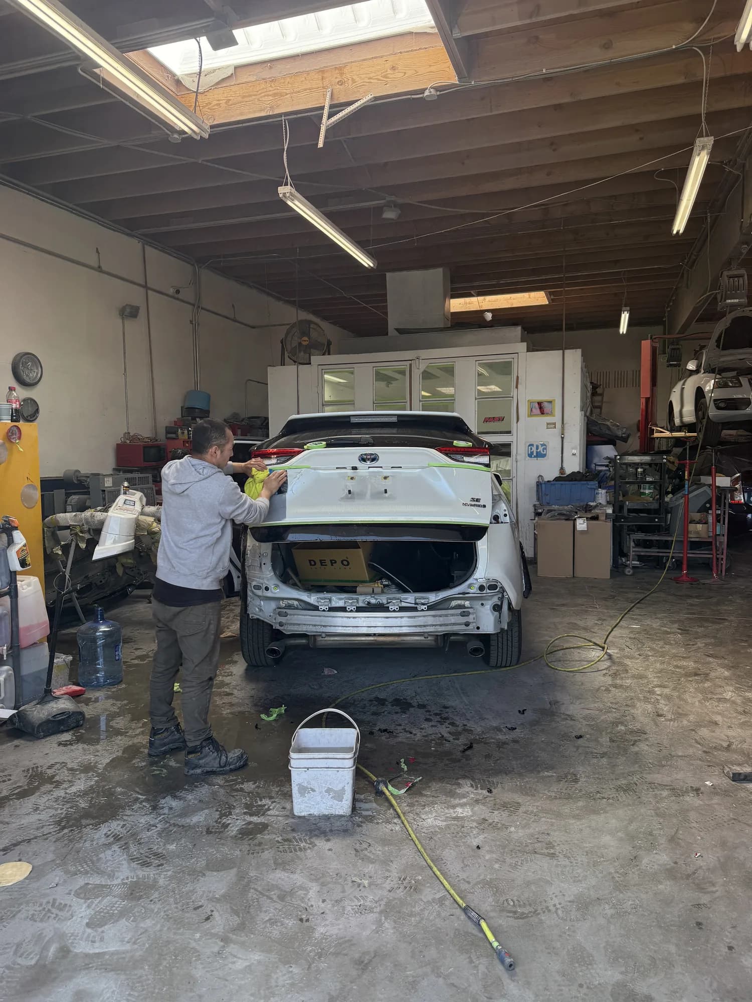 Technician working on a stripped rear panel inside the workshop